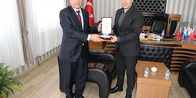 Keban Kaymakamı Atalık Müdür Kaya'ya Plaket verdi